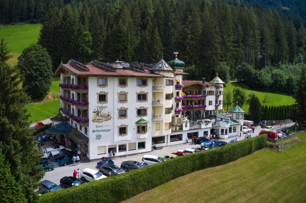 un grande edificio con auto parcheggiate in un parcheggio di Hotel Silberberger a Oberau