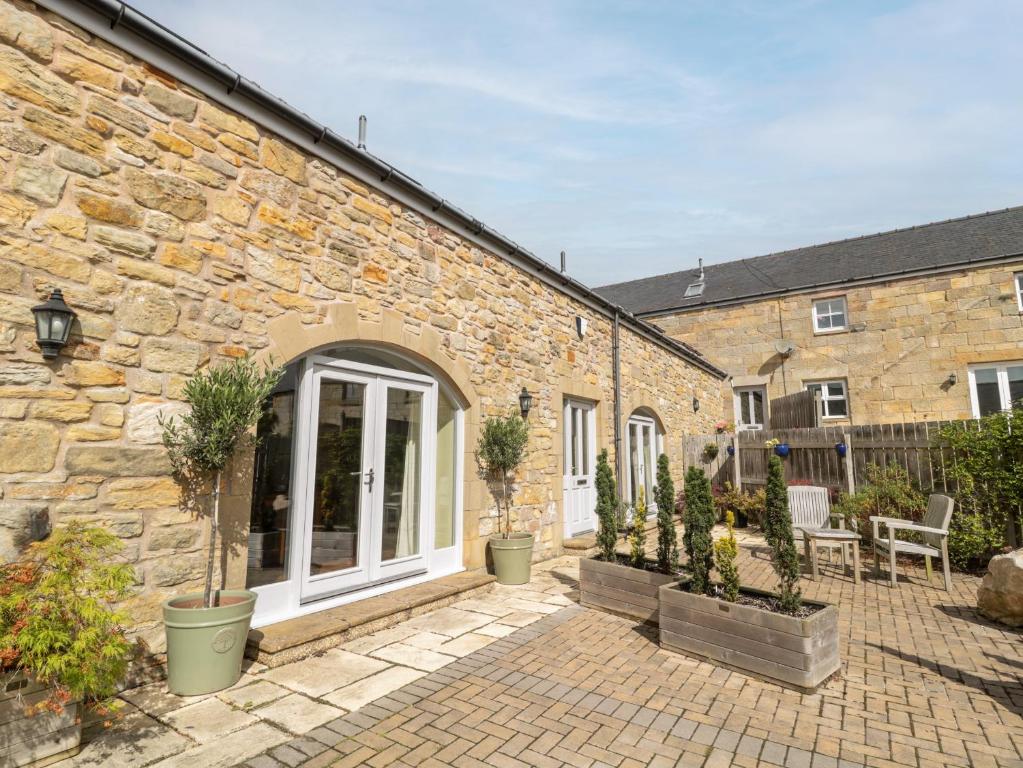a brick building with potted plants in front of it at Calm Skies in Berwick-Upon-Tweed