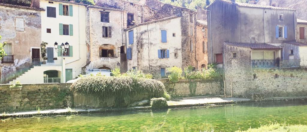 een groep gebouwen naast een waterlichaam bij La Galine, Maison de village medieval in Lunas