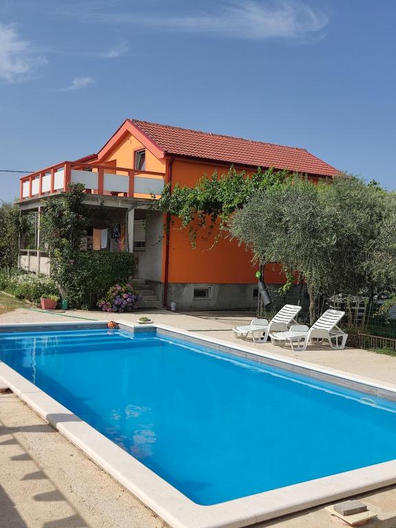 a swimming pool in front of a house at Apartment Velebit with swimming pool - 10km from sea - 20km from Zadar in Benkovac