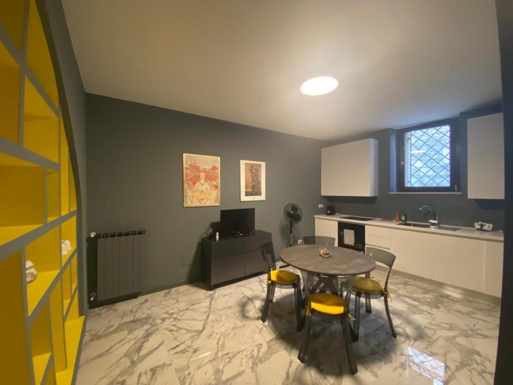 a room with a table and chairs and a kitchen at Modern city center apartment in Benevento