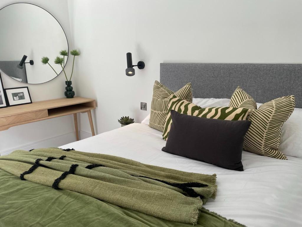 ロンドンにあるBrand new 3-bedroom home in Londonのベッドルーム(枕、鏡付)