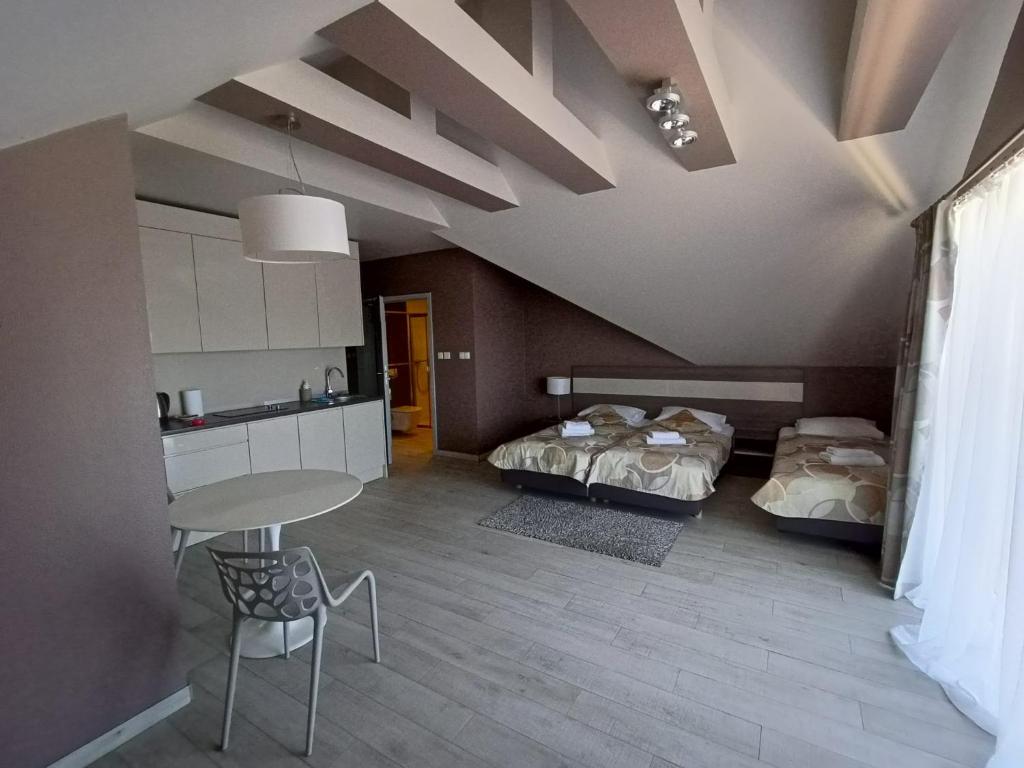 a room with two beds and a table and chairs at Apartament Tignes Czarna Góra in Sienna