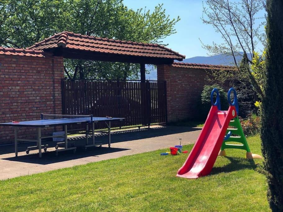 un parque infantil con un tobogán rojo y una mesa de picnic en Vikendica Drina Hill Loznica en Loznica