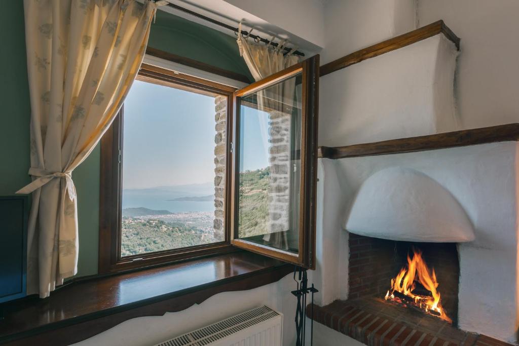 a fireplace in a room with a window and a lamp at Archontiko Anemos in Makrinitsa