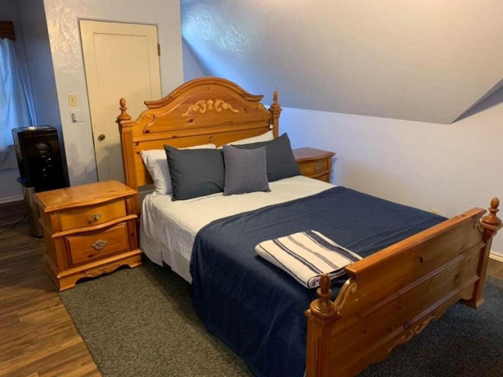 ein Schlafzimmer mit einem großen Holzbett mit blauer Bettwäsche und Kissen in der Unterkunft Diamond Apartment -Downtown Location in Lawton