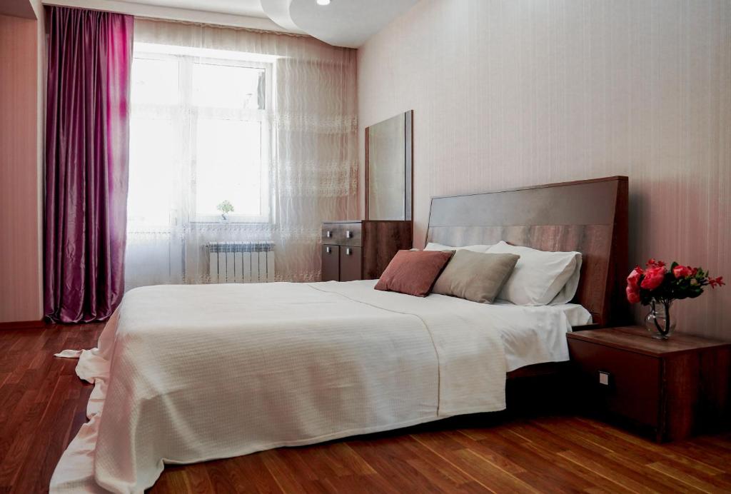 um quarto com uma cama grande e uma janela em Комфортная квартира возле метро em Baku