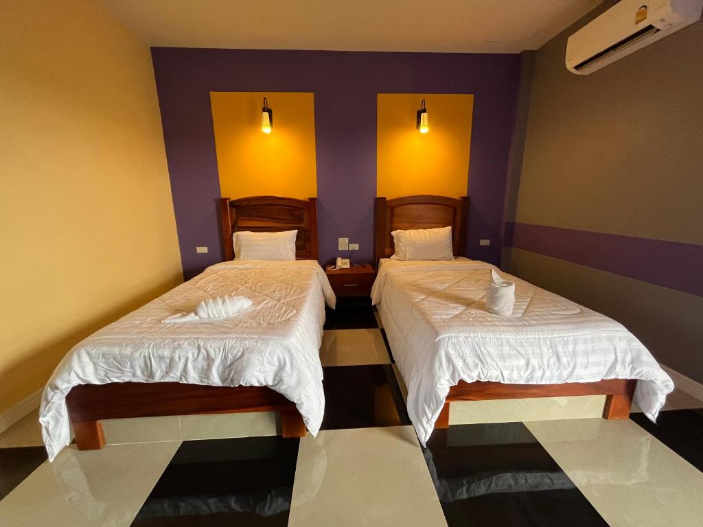 Postel nebo postele na pokoji v ubytování The Palm Resort Kampeang Saen