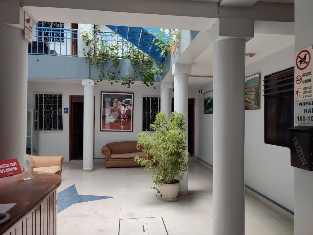 un vestíbulo con sofás y una planta en un edificio en Hostal PASCO, en Quito
