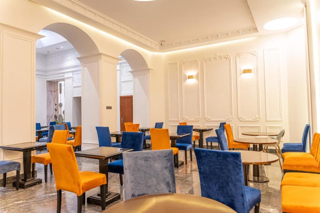 a restaurant with tables and chairs in a room at Hotel Majestic in Casablanca