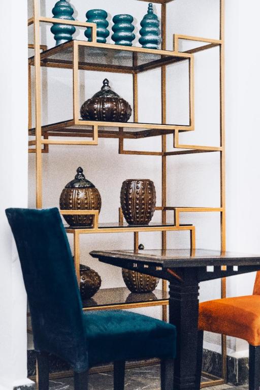 a dining room with a table and chairs and shelves with vases at Hotel Majestic in Casablanca