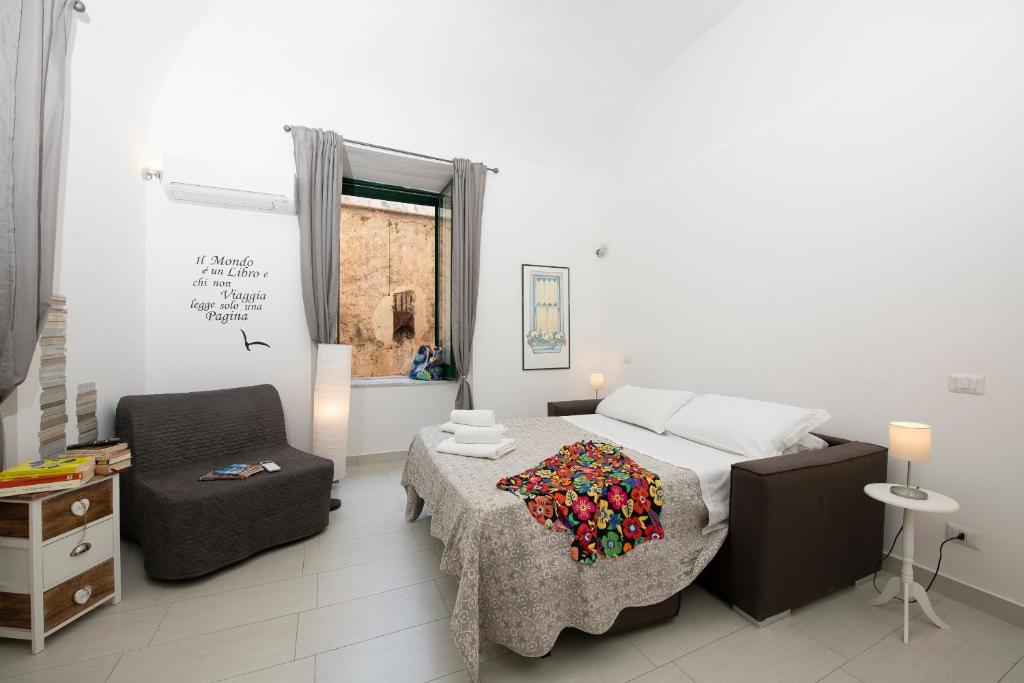 a bedroom with a bed and a chair at Amalfi 90 - holiday house close the beach in Atrani