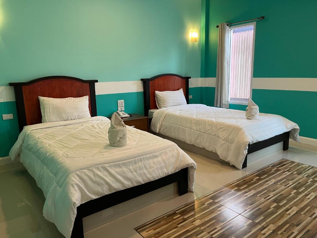 Postel nebo postele na pokoji v ubytování The Palm Resort Kampeang Saen