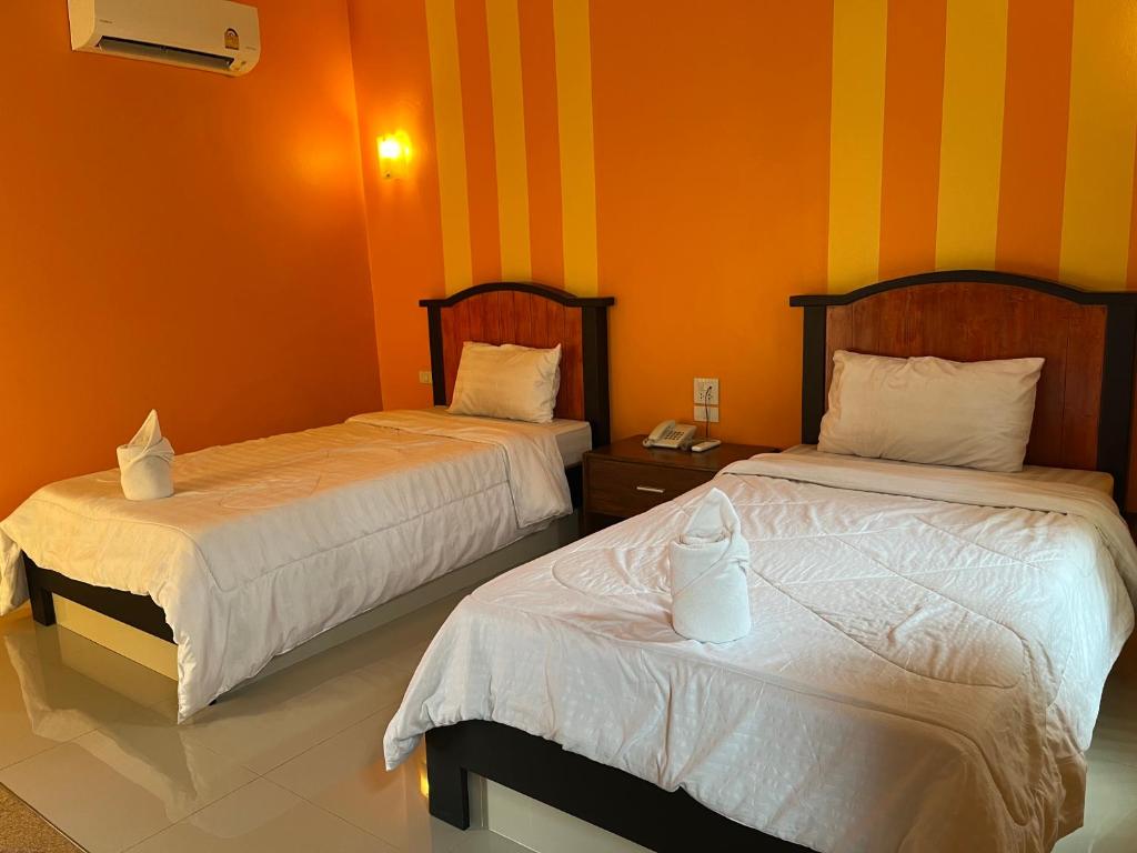 Postel nebo postele na pokoji v ubytování The Palm Resort Kampeang Saen