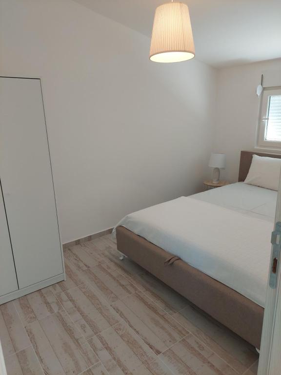 Un dormitorio blanco con una cama y un espejo. en Apartmani.Sutomore, en Sutomore