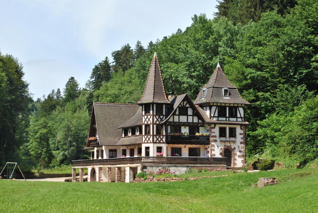 une ancienne maison avec deux tours sur un champ verdoyant dans l'établissement Le Saint moulin de La Petite Pierre, à Lohr