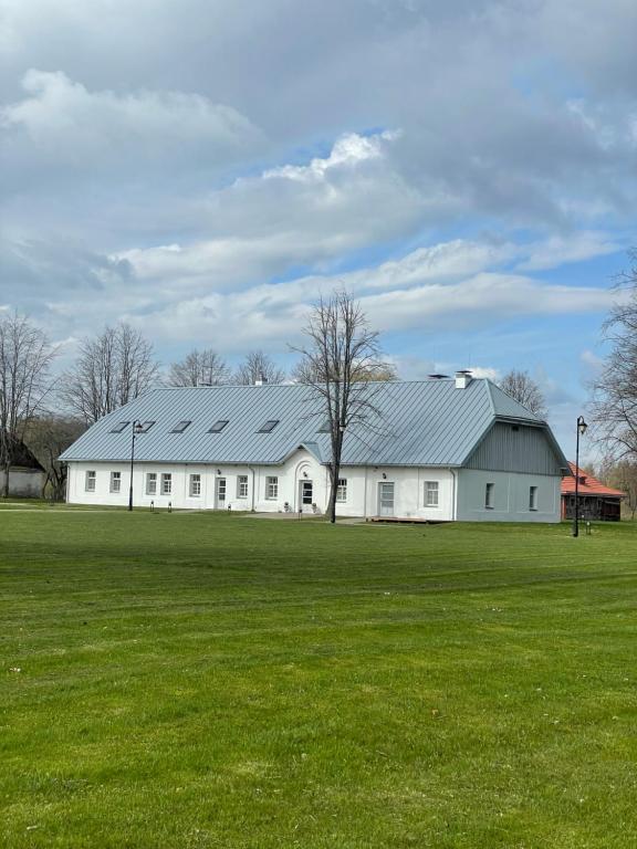 a large white barn with a large green field at A. Smetonos Dvaro Smetonienės svetainė 
