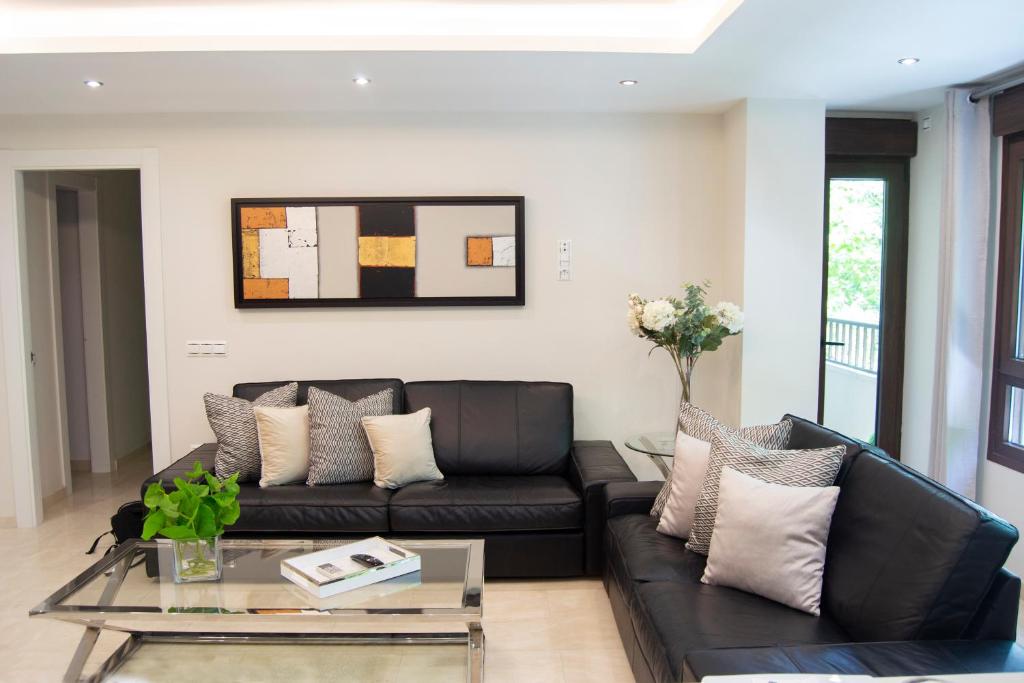 a living room with a black couch and a table at Edificio Ramiro in Marbella