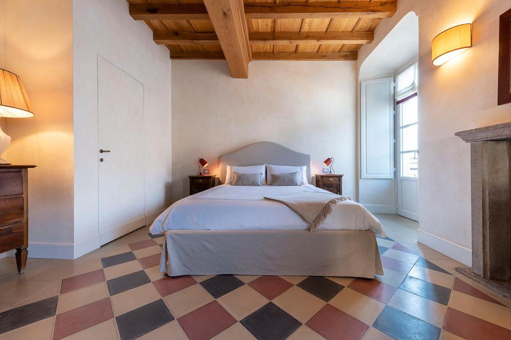 a bedroom with a bed and a checkered floor at Isola Bella Apartments Suite Ortensia in Stresa