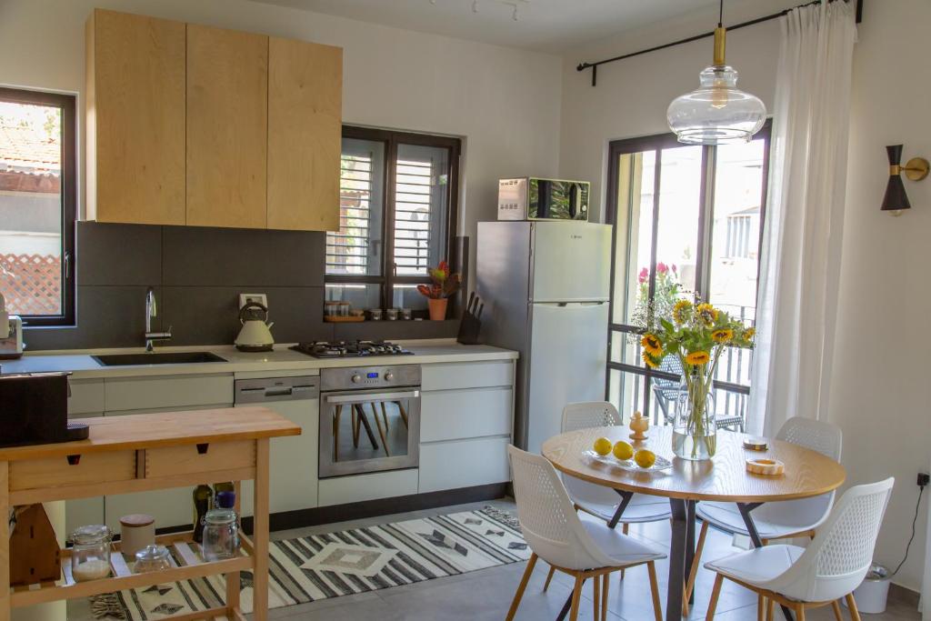 a kitchen with a table with chairs and a refrigerator at The Alexander Apartment in Tel Aviv