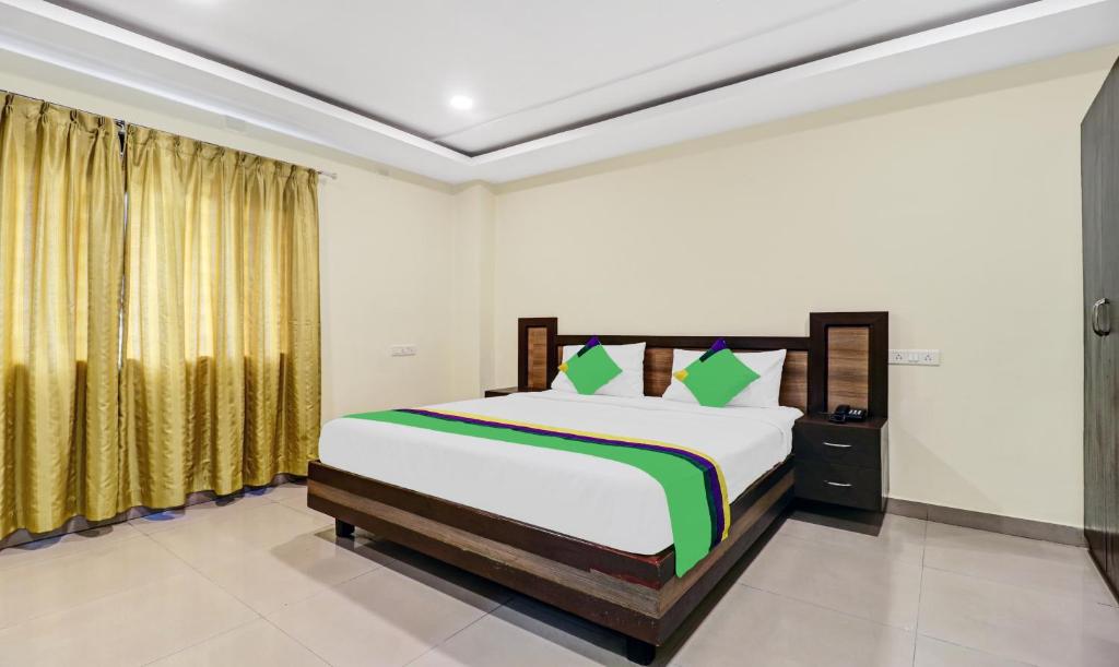 1 dormitorio con 1 cama grande y cortinas en Treebo Trend Millennium Plaza, en Bangalore