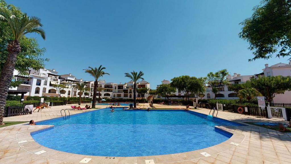 una piscina en un complejo con palmeras y edificios en Penthouse Anchoa-A Murcia Holiday Rentals Property, en Roldán