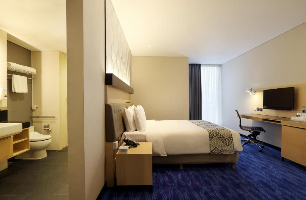 Pokój hotelowy z łóżkiem i biurkiem w obiekcie AI Hotel Jakarta Thamrin w Dżakarcie