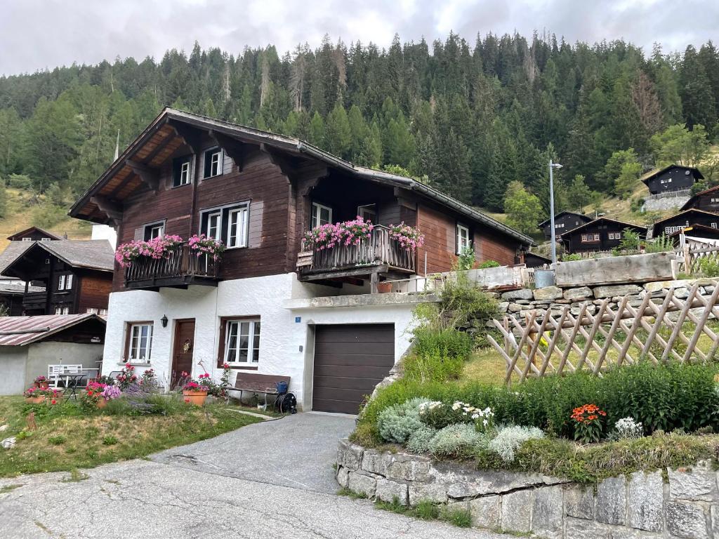 a house with flowers on the balconies of it at Haus Bortis in Niederwald