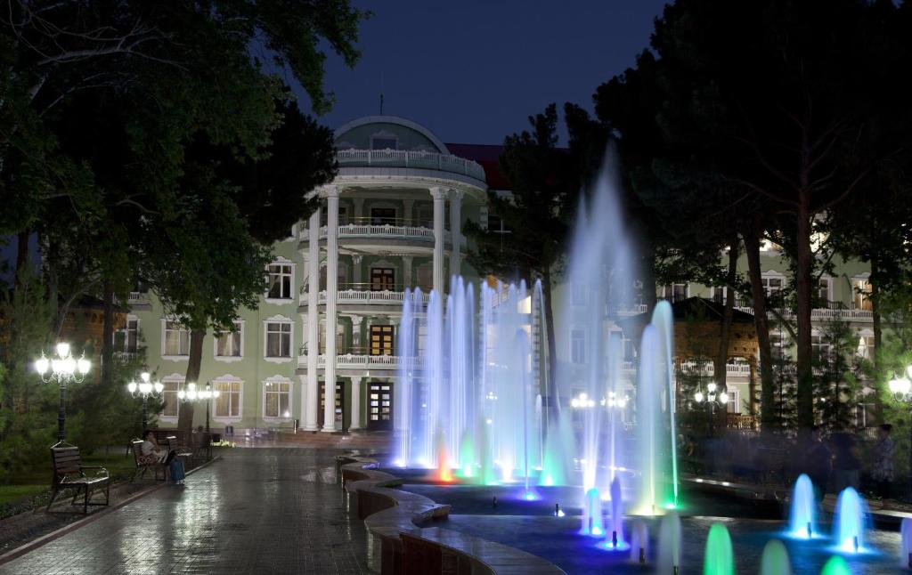 una fuente frente a un edificio por la noche en Bahoriston Hotel, en Qayraqqum