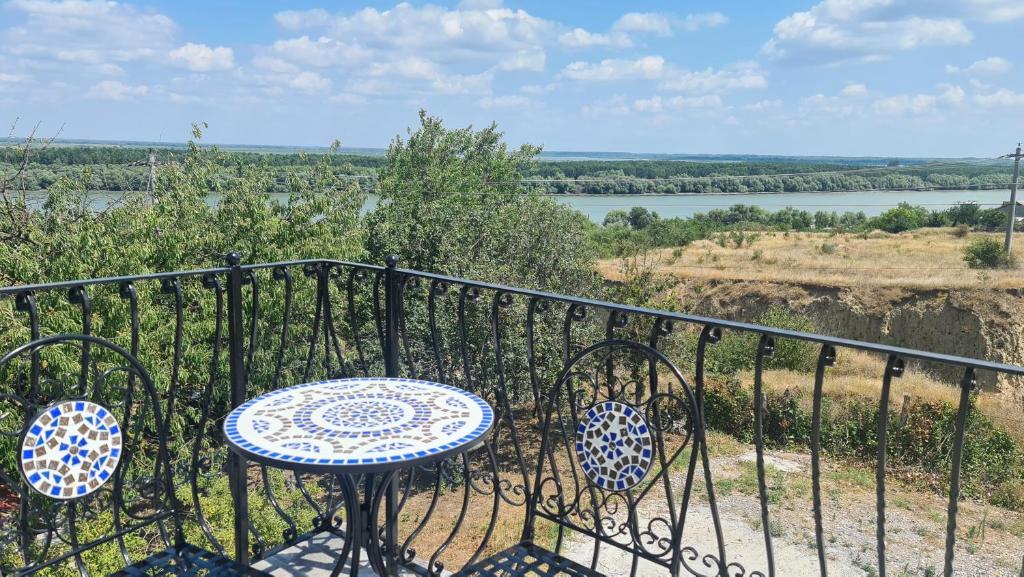a table and chairs on a balcony with a view of a river at Casa Mavis in Mahmudia