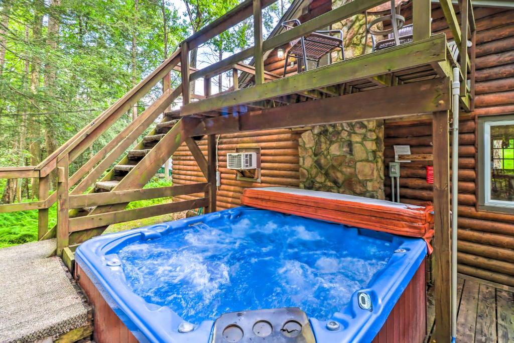 a large blue tub sitting in front of a cabin at Secluded and Quiet Pocono Mountain Cabin with Hot Tub! in Kunkletown