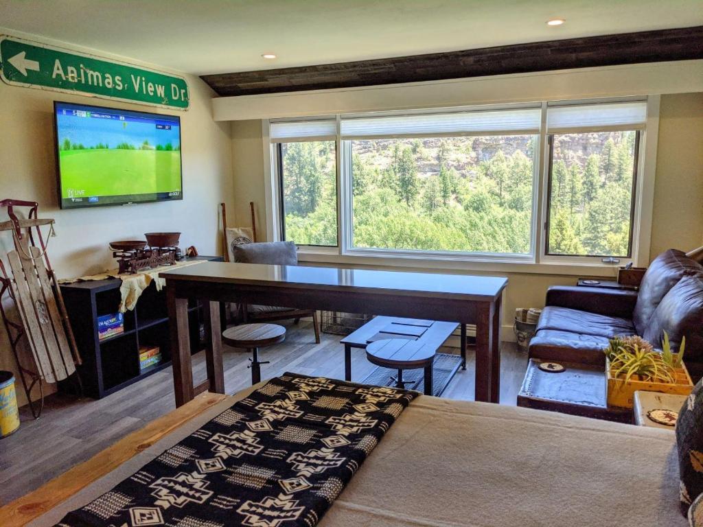 a living room with a large table and a tv at Tamarron Lodge Studio 205 in Durango