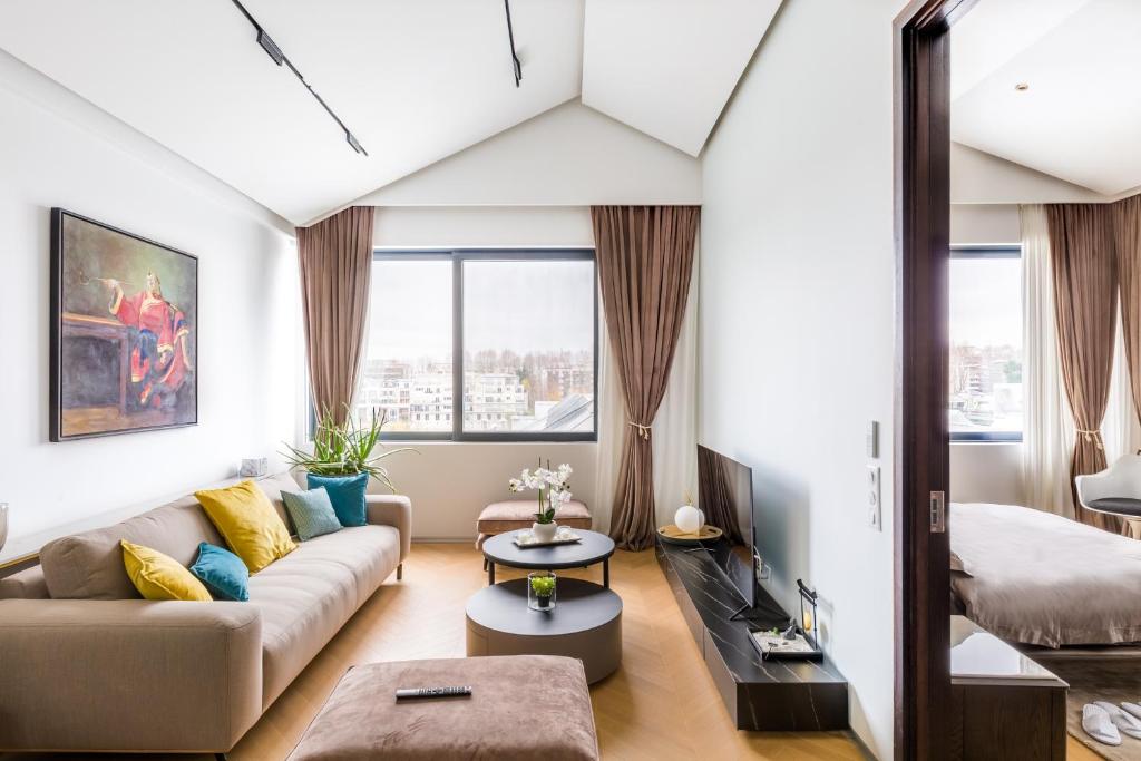- un salon avec un canapé et un lit dans l'établissement Ravissant loft avec vue sur Seine, à Courbevoie