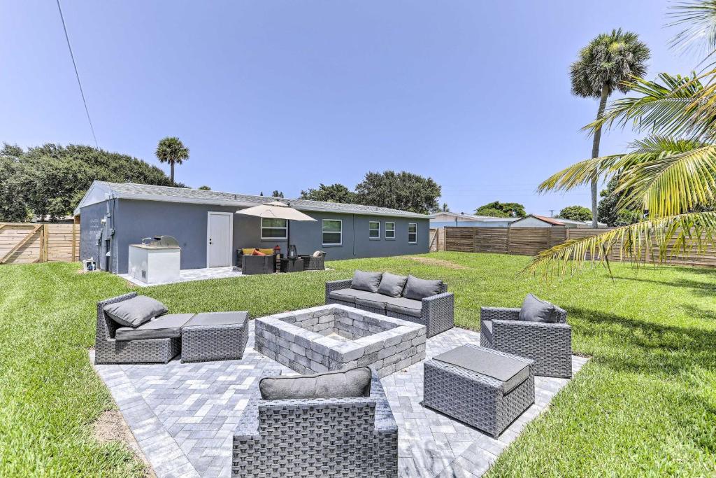 une cour avec un foyer extérieur dans l'herbe dans l'établissement Beach House with Outdoor Kitchen, Walk to Coast, à Cocoa Beach