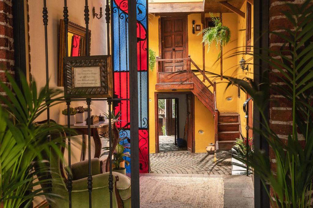 une allée avec des portes colorées en verre teinté dans un bâtiment dans l'établissement Hotel Rural Coliving Los Realejos, à Los Realejos