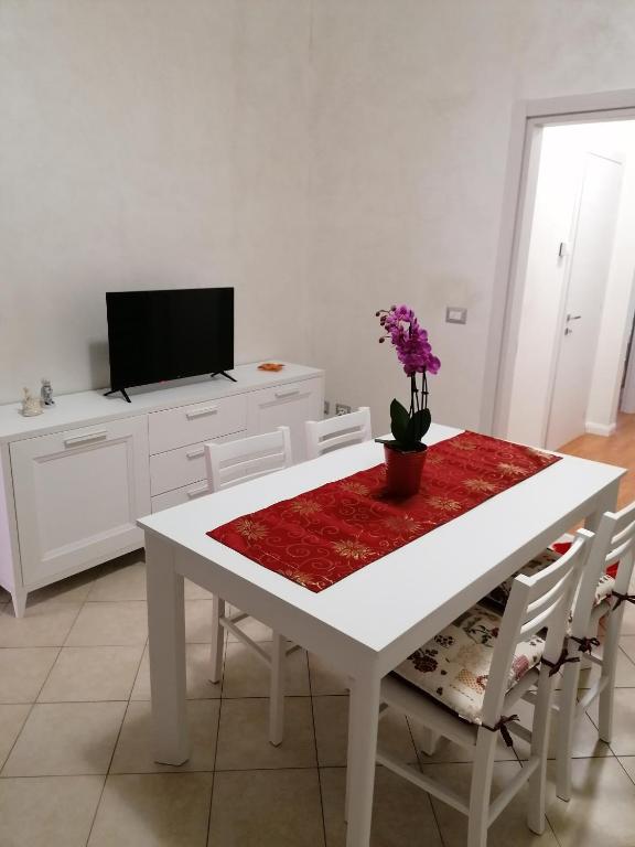 a white kitchen with a white table with flowers on it at IN CENTRO in Porto SantʼElpidio