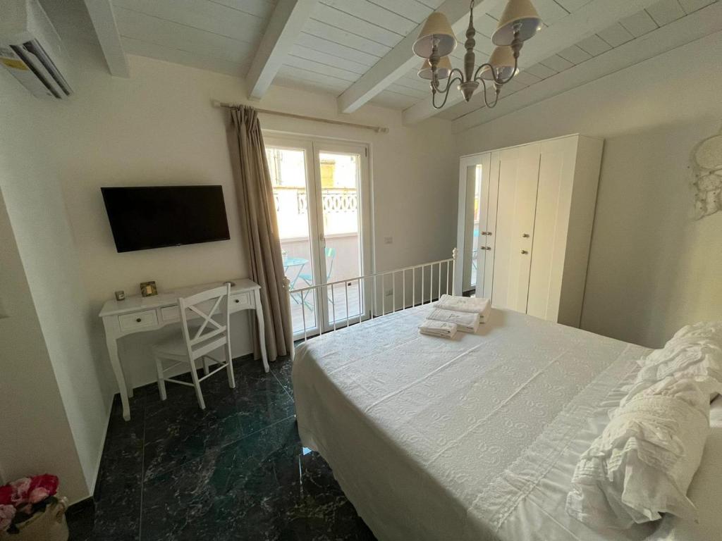 sypialnia z łóżkiem, biurkiem i telewizorem w obiekcie Supriani Luxury B&B w mieście Acquaviva delle Fonti