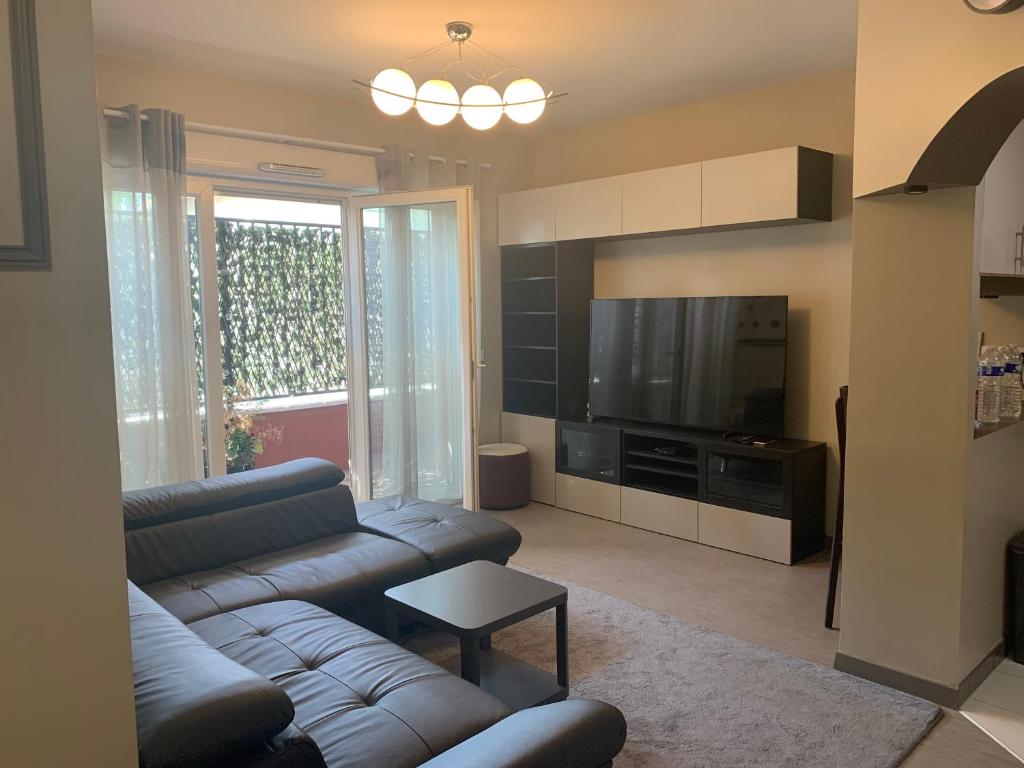 un salon avec un canapé et une télévision dans l'établissement Luxurious Flat in Bondy, (In front of the Train station), à Bondy