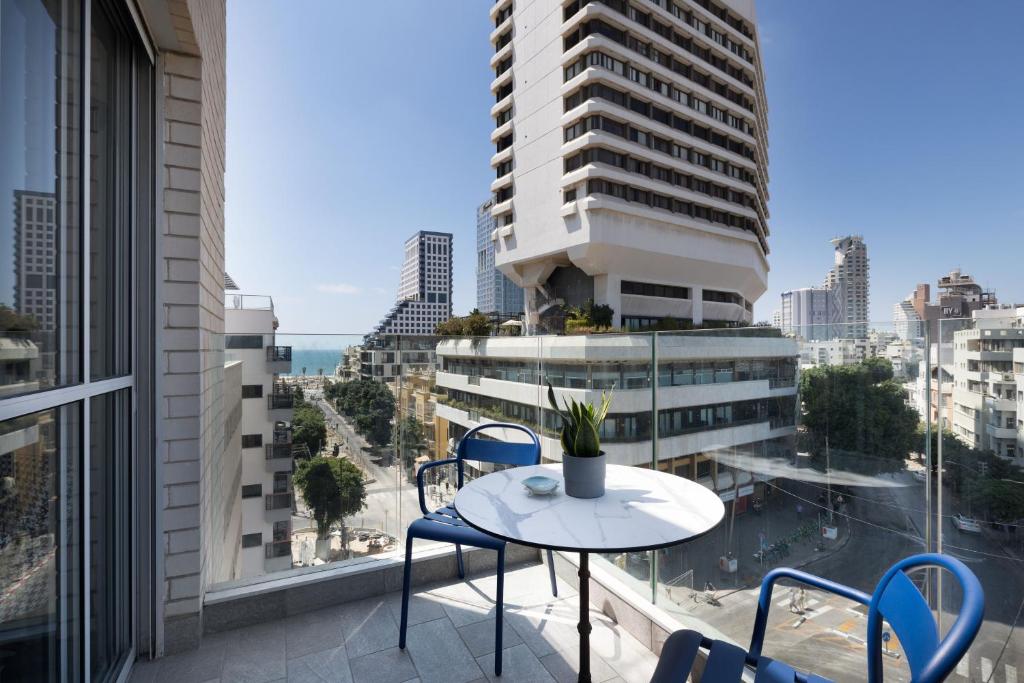 a balcony with a table and chairs and a view of the city at Bauhaus Boutique by TLV2rent in Tel Aviv