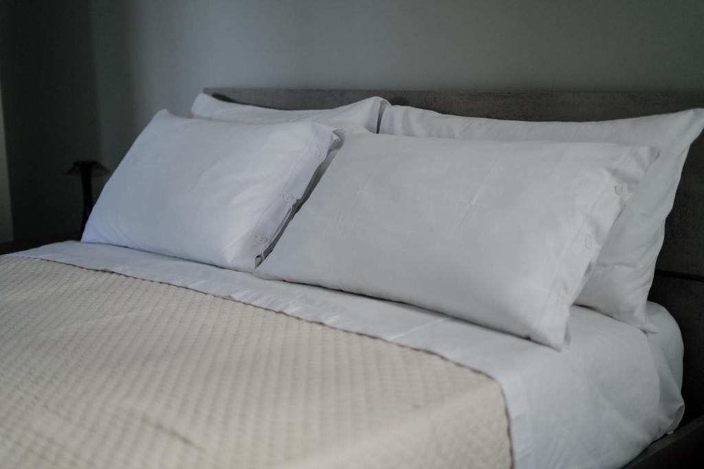 バーリにあるDOMUS RESIDENCE - CESARE -のベッド(白いシーツ、枕付)
