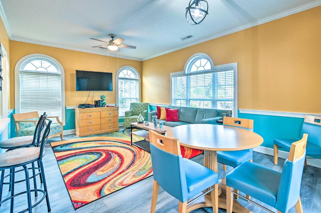 a living room with a table and chairs and a couch at Colorful Myrtle Beach Golf Club Condo with Pool in Myrtle Beach