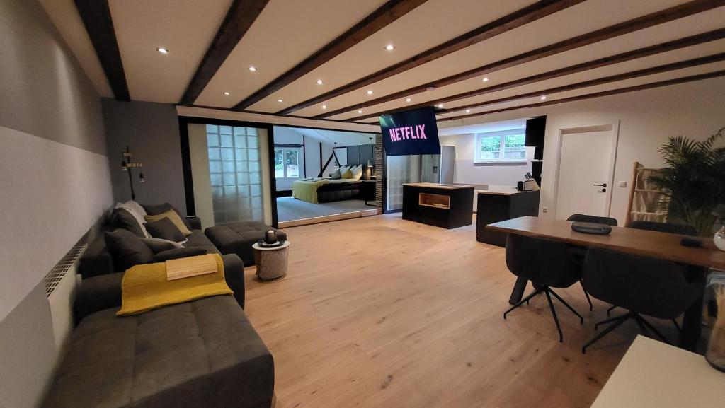 een woonkamer met een bank en een bord met uitgang bij Modern Loft near City, free parking, fast wifi in Bochum