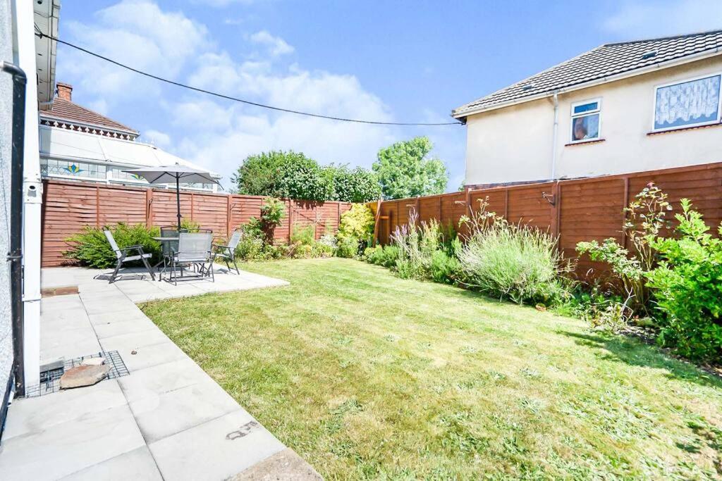 a backyard with a fence and a lawn with chairs at Beautiful 3 bedroom home, 10 minutes walk to Beach. in Cleethorpes