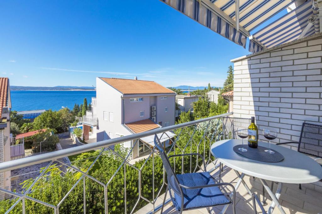 einen Balkon mit einem Tisch, Stühlen und Meerblick in der Unterkunft Blue Pearl Apartments in Crikvenica