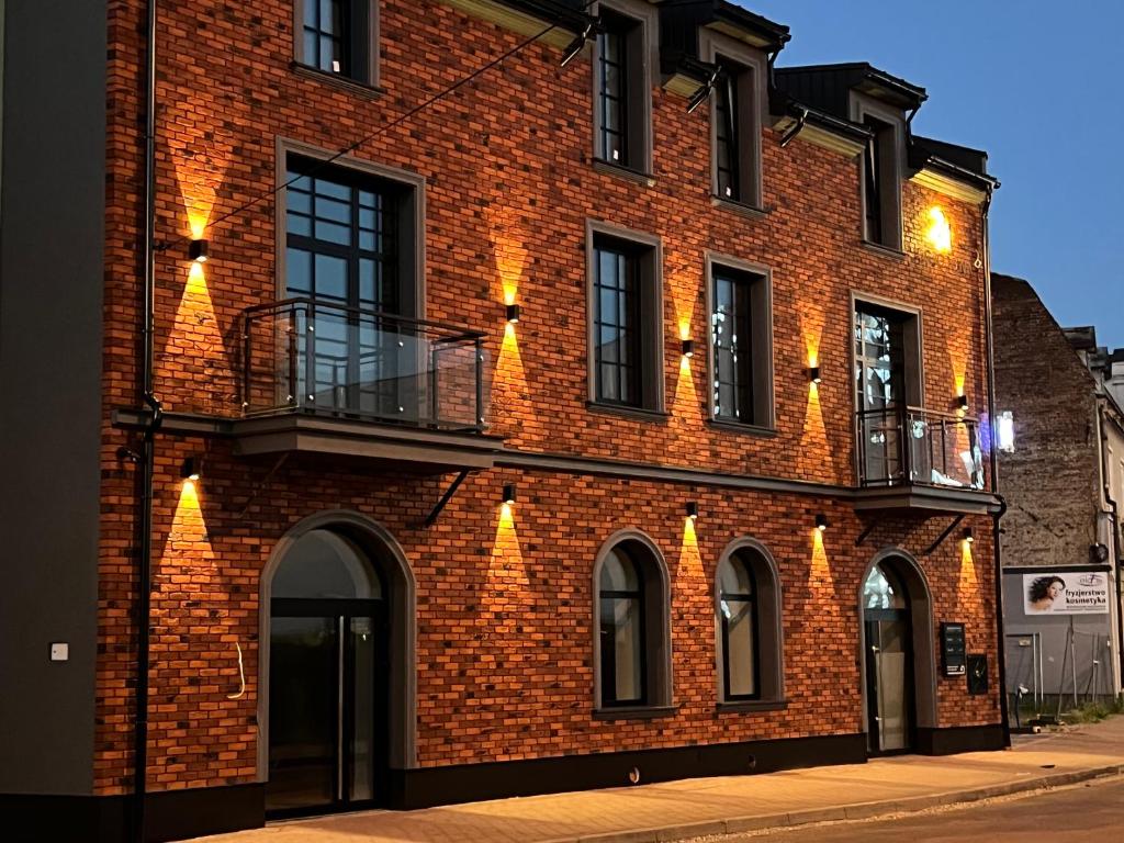 a brick building with lights on the side of it at Ogrodowa Premium in Gorlice