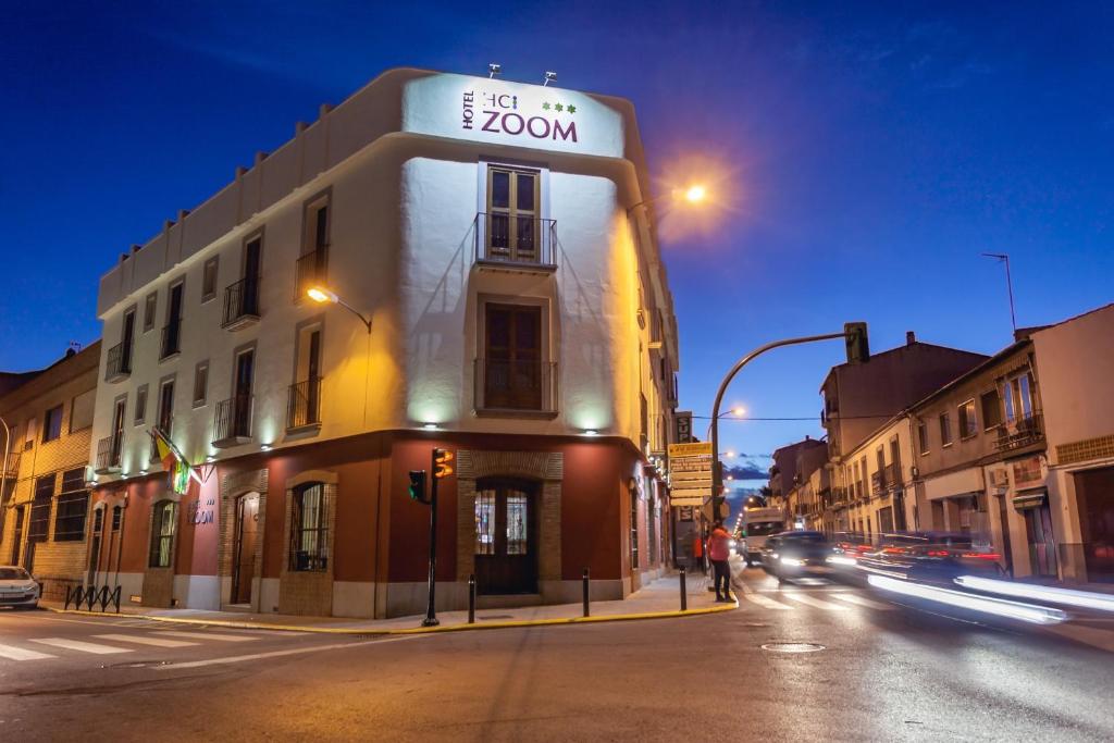 un edificio en la esquina de una calle de la ciudad por la noche en Hotel Hc Zoom, en Pozoblanco