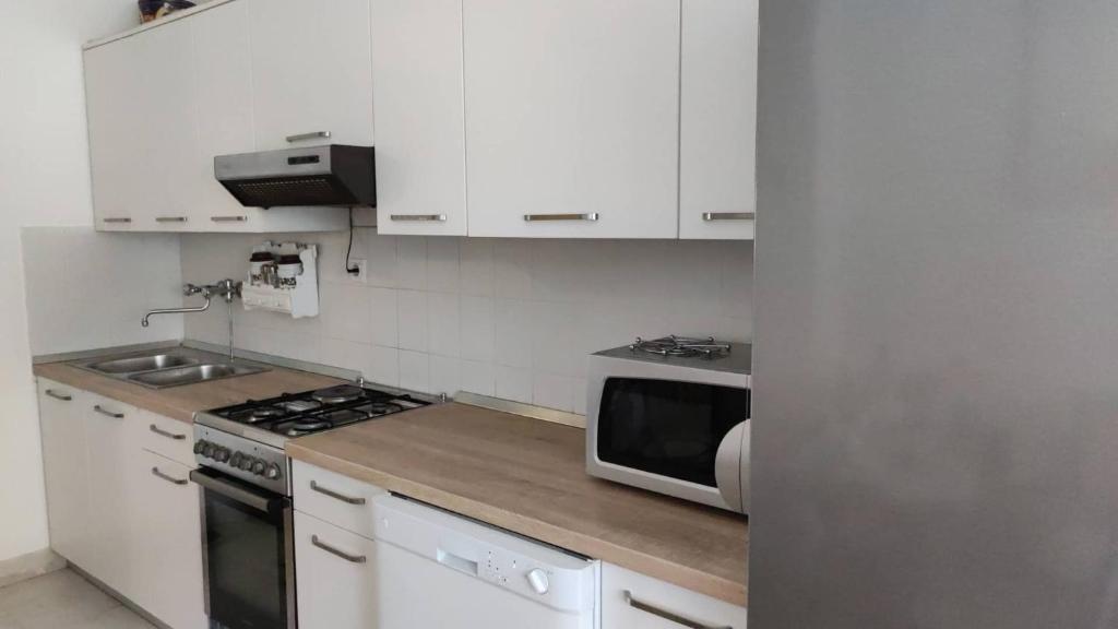a kitchen with white cabinets and a microwave at Luka in Split
