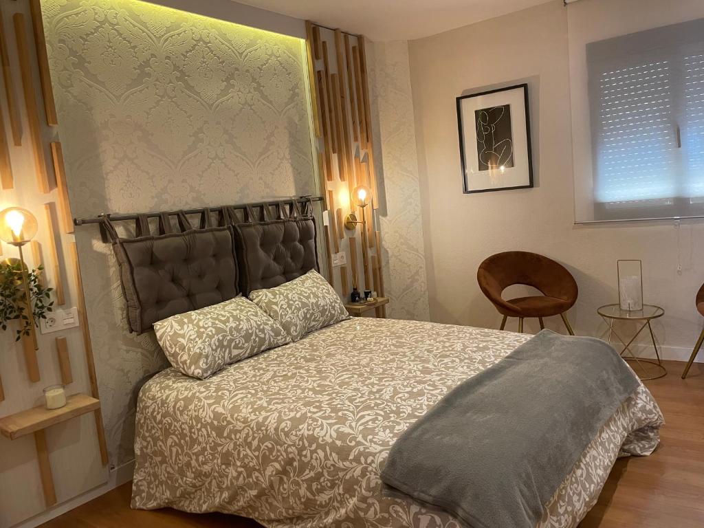 a bedroom with a bed and a chair at Precioso apartamento muy cerca de Méndez Alvaro in Madrid