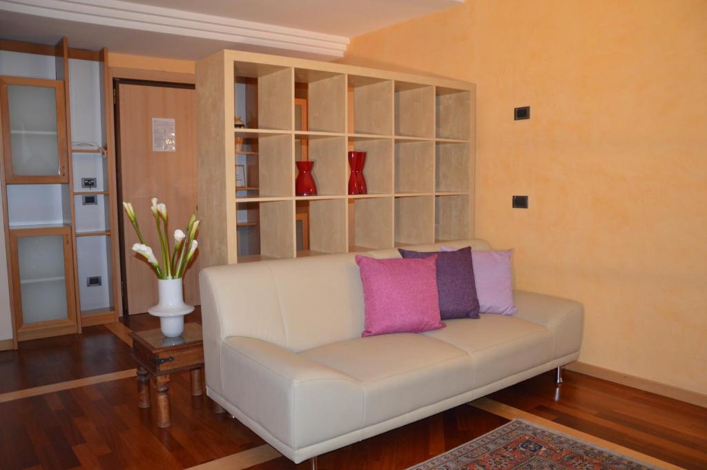 パドヴァにあるAppartamenti Europaのリビングルーム(ピンクの枕と白いソファ付)