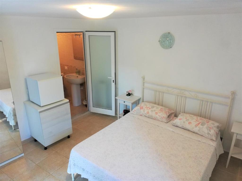 a bedroom with a bed and a bathroom with a sink at Lucrae' in Finale Ligure